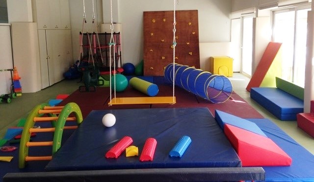 A sensory integration therapy room with swings and mats